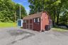 Red-sided shed with a gambrel roof and double doors