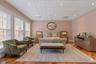 Spacious room featuring wood-finish flooring and multiple tall windows with integrated blinds
