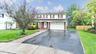 Traditional-style home featuring a garage, fence, aphalt driveway, a front yard, and brick siding
