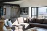 Living room with a barn door, vaulted ceiling, and an AC wall unit