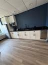 Kitchen featuring refrigerator, white cabinetry, a paneled ceiling, light wood-type flooring, and dark stone counters