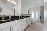 Primary ensuite bath with dual vanities and a walk in shower