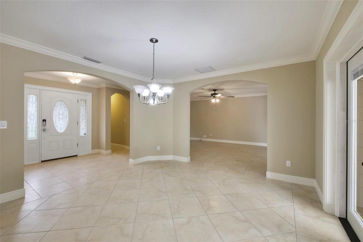 Step through the ELEGANT ETCHED GLASS FRONT DOOR and into a home where crown molding and tile flooring flow throughout—with no carpet to be found.