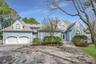 View of front of home featuring a garage, roof with shingles, decorative driveway, and french doors