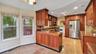 Kitchen with stainless steel appliances, granite finish floor, visible vents, and a sink
