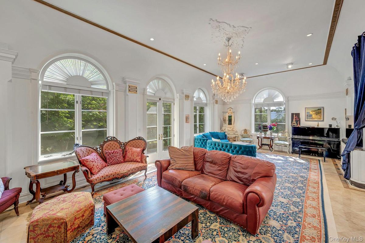 Living room with a chandelier, recessed lighting, crown molding, and light tile patterned floors