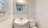 Bathroom featuring vanity, tile walls, and toilet