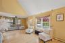 Living room featuring a baseboard radiator, high vaulted ceiling, light wood-type flooring, healthy amount of natural light, and ceiling fan