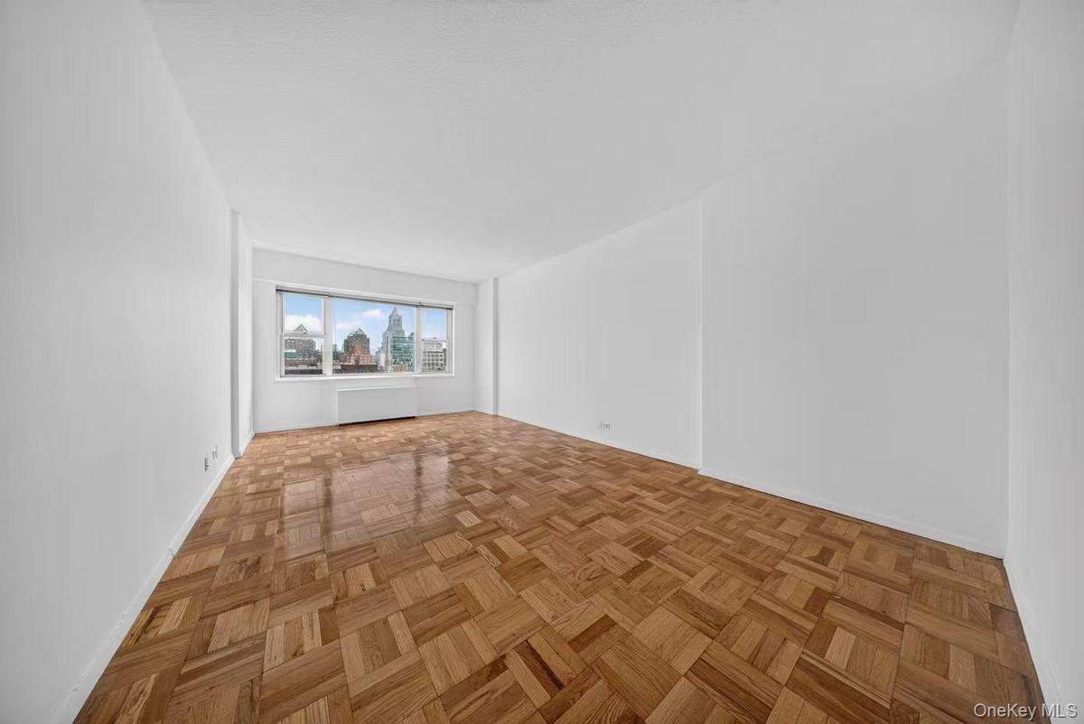 Bright interior space featuring parquet wood flooring and large windows