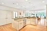 Kitchen island with recessed lighting, decorative light fixtures, light wood-style flooring, a center island with sink, and stainless steel Bosch dish