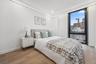 Bedroom featuring light wood-style flooring, baseboards, recessed lighting, and a view of city