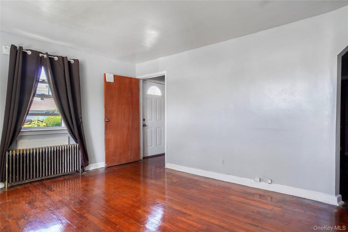 Interior space featuring wood-finish flooring, light gray walls, and white baseboards