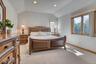 Bedroom with light colored carpet, multiple windows, lofted ceiling, and recessed lighting