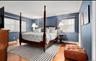 Bedroom with multiple windows, wood finished floors, and a baseboard radiator