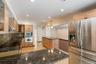 Spacious kitchen featuring granite countertops, light wood cabinetry, stainless steel appliances including a double oven and refrigerator, and recesse