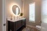 The half bathroom is beautifully designed with a backlit mirror and floating vanity.