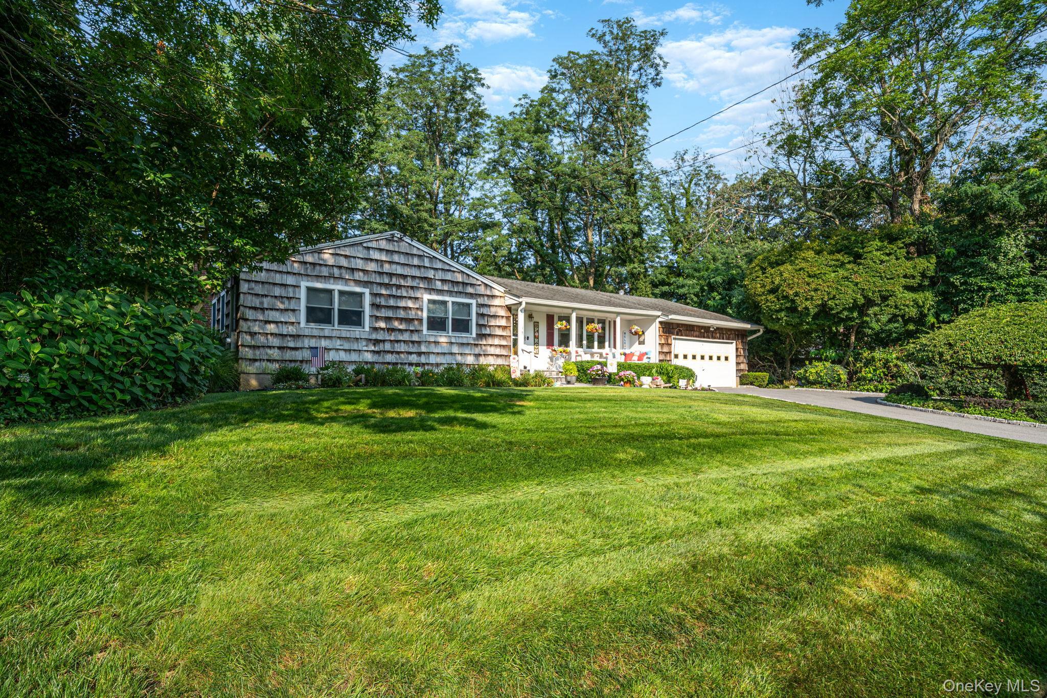 Single-story residence featuring shingle siding and a white garage door