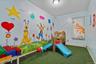 Room featuring light blue walls with colorful murals, artificial turf flooring, and a ceiling-mounted light fixture