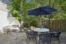 Outdoor patio area featuring gravel surfacing and mature trees