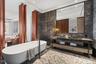 Full bathroom featuring a freestanding tub, a sink, tile walls, and double vanity