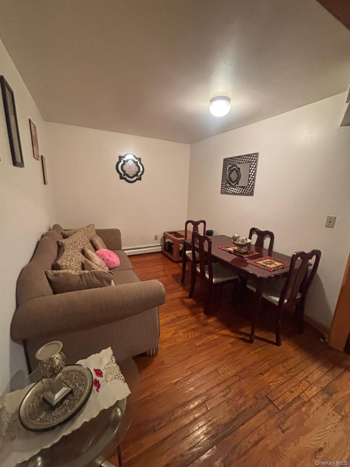 Dining area with dark wood finished floors and baseboard heating