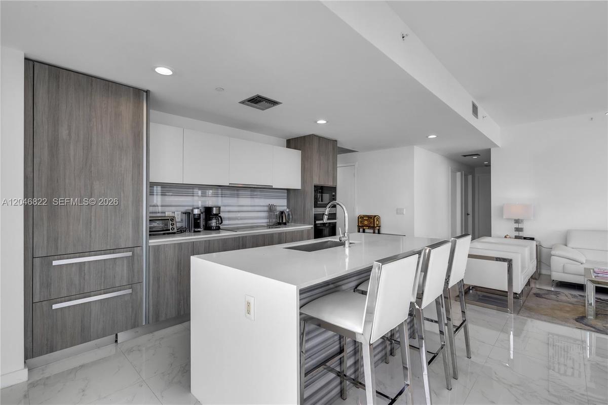 Dining area beneath designer pendants with panoramic city views