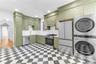 Upper level custom eat-in kitchen with stainless steel appliances and washer / dryer