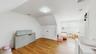 Additional living space with radiator heating unit, visible vents, vaulted ceiling, and light wood-style flooring