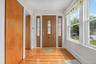 Entryway featuring a paneled door with decorative glass inserts, sidelight windows with matching decorative glass, and wood-finish flooring