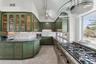 Kitchen featuring tasteful backsplash, green cabinets, stainless steel range with gas cooktop, dark stone countertops, and light tile patterned floors