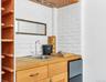 Kitchen with sink, wooden counters, and brick wall