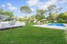Fenced backyard with a wooden deck and a patio area