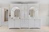 Bathroom with a decorative wall, wainscoting, double vanity, light tile patterned floors, and inlaid floor details