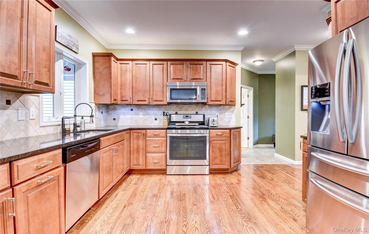 Kitchen featuring wood flooring, recessed lighting, granite counters, and crown molding