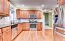 Kitchen featuring wood flooring, recessed lighting, granite counters, and crown molding