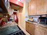 Well maintained kitchen, with light oak cabinets, granite countertop, tiled backsplash.