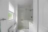 Bathroom with a stall shower, vanity, and lofted ceiling