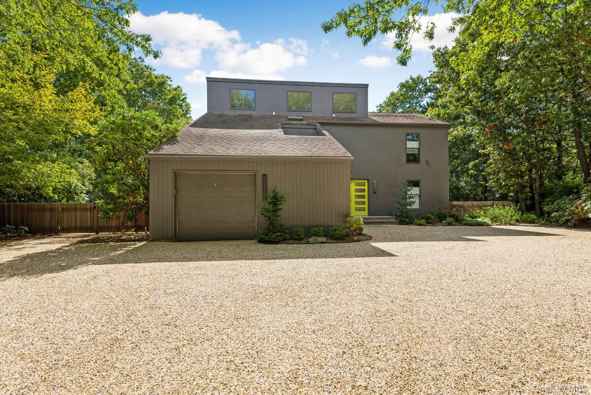 View of front of home featuring driveway, a garage, and a shingled roof