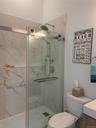Bathroom with vanity and a marble finish shower