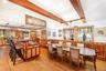 Dining area with light wood finished floors, arched walkways, a wainscoted wall, and recessed lighting
