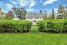 Colonial home featuring a front yard and a chimney