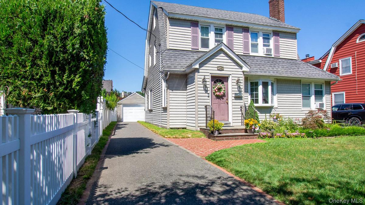 Traditional two-story colonial with gray siding and coordinating roof