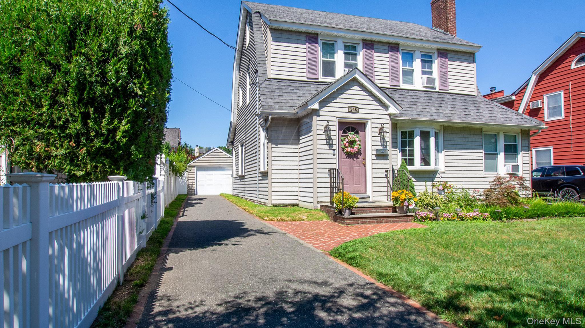 Traditional two-story colonial with gray siding and coordinating roof