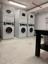Shared laundry room with stacked washing machine and dryer