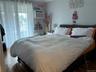 Bedroom featuring a wall mounted AC and hardwood / wood-style flooring