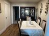 Dining area with a drop ceiling and dark wood-type flooring