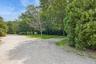 View of dirt / gravel road featuring a wooded view