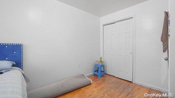 Unfurnished bedroom featuring wood finished floors and a closet