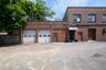 The commercial building has two garage bays attached, entrance is provided through a separate entrance to the right of the right garage door.
