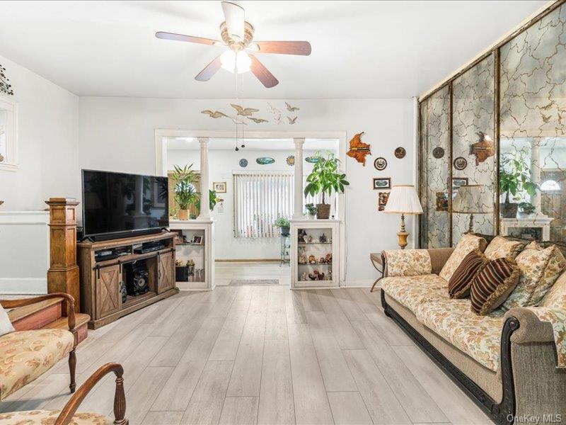 Living area featuring ceiling fan and light inished floors